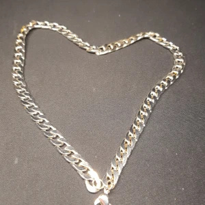 Silverfärgat halsband med kedjedesign - Stilrent silverfärgat halsband med en klassisk kedjedesign. Perfekt för att ge en elegant touch till din outfit. Halsbandet har en enkel och tidlös stil som passar till många olika tillfällen. Den är inte riktigt silver