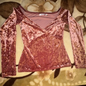 Långärmad rosa tröja sammet NA-KD - Mycket fint skick  - NA-KD. ”Velvet Off Shoulder Top”. Långärmad. V-ringning. Stretchig. Material i sammet. Figurnära, figurkramande och framhävande. Fin rosa färg. Storlek: S. Material: 92% polyester, 8% elastan. Maskintvätt i 30 grader. Skick: Mycket fint. Nypris: 199 kr. MÅTT: Längd: 48,5 cm. Bredd: 38 cm. Ärmlängd: 55 cm. Axelbredd: 36 cm. V-ringning djup: 22,5 cm. Midja: 30,5 cm. 