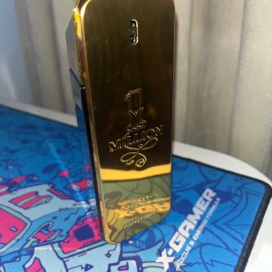 1 Million parfym från Paco Rabanne 100ml - Säljer en lyxig 1 Million parfym från Paco Rabanne. Flaskan är formad som en guldtacka och har en glänsande guldton. Förpackningen är elegant med en bild av en man i kostym. Perfekt för den som vill ha en doft med attityd och stil. Knappast använd nästan helt full kanske 95ml av 100ml