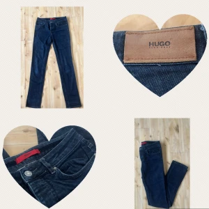 Lågmidjade jeans från Hugo Boss - Äkta snygga mörkblå skinny jeans från Hugo Boss med klassisk design. De har flera knappar samt en läderetikett med logotyp på baksidan. Perfekta för en stilren look. Köptes för 1500 kr.