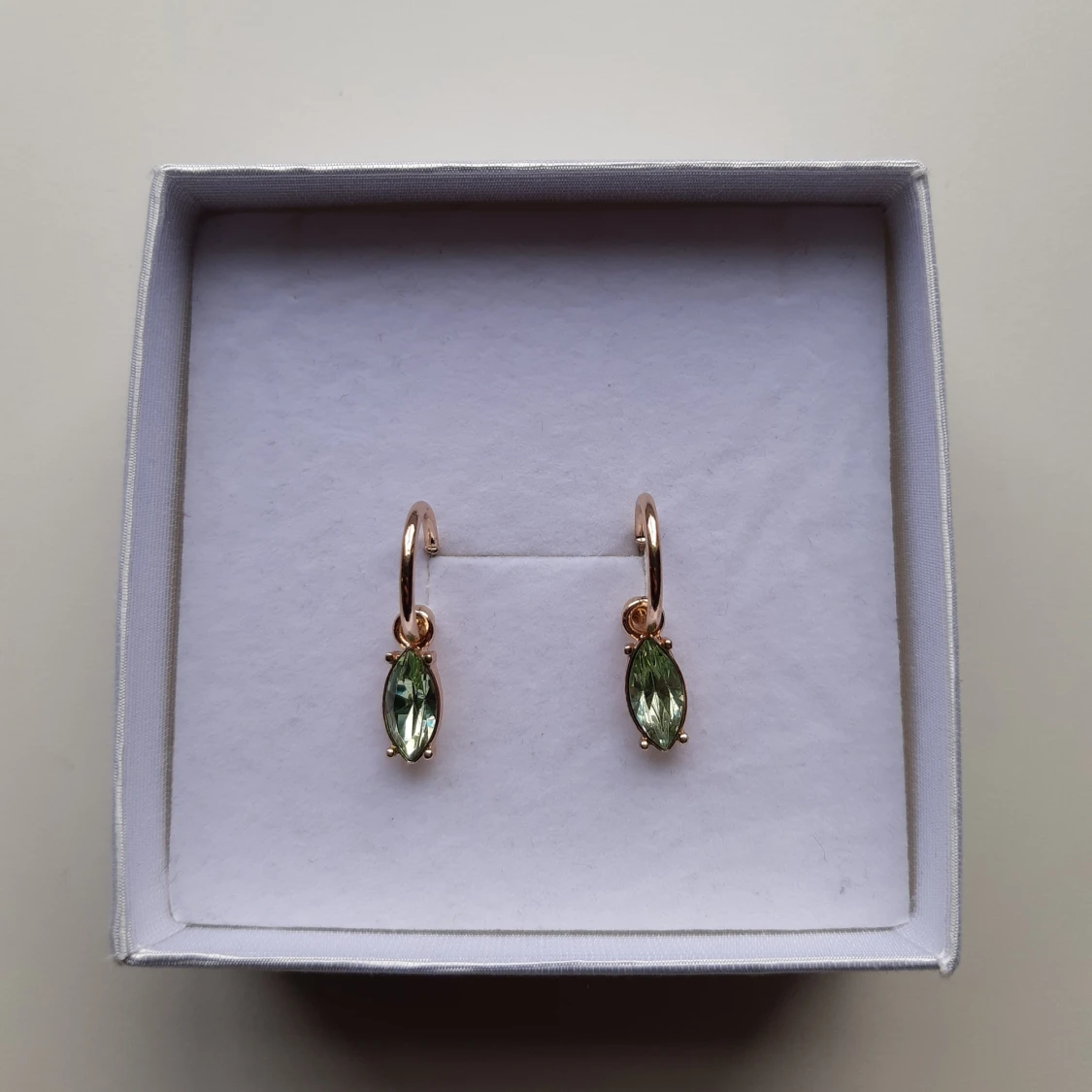 Guldörhängen med gröna stenar