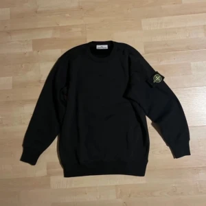Svart tröja från Stone Island - "Jag säljer en äkta Stone Island-tröja i mycket gott skick Jag tar även Emot byte. Tröjan är i storlek M och har en stilren design med det ikoniska Stone Island-logotypen på ärmen. 