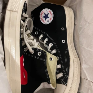 Svarta Converse Play sneakers - Snygga svarta Converse Play sneakers med det ikoniska hjärtmotivet. Skorna har vita snören och en klassisk vit sula. Perfekta för en stilren look.