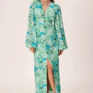 ADOORE Positano Klänning 32 - Perfekt klänning för sommarfester, student, midsommar och bröllop. Nyskick, oanvänd, storlek 32. Prislappen sitter kvar. Nypris för liknande klänningar på hemsidan är 1 695 kr men är slutsåld, så jag säljer den för ett högre pris. 