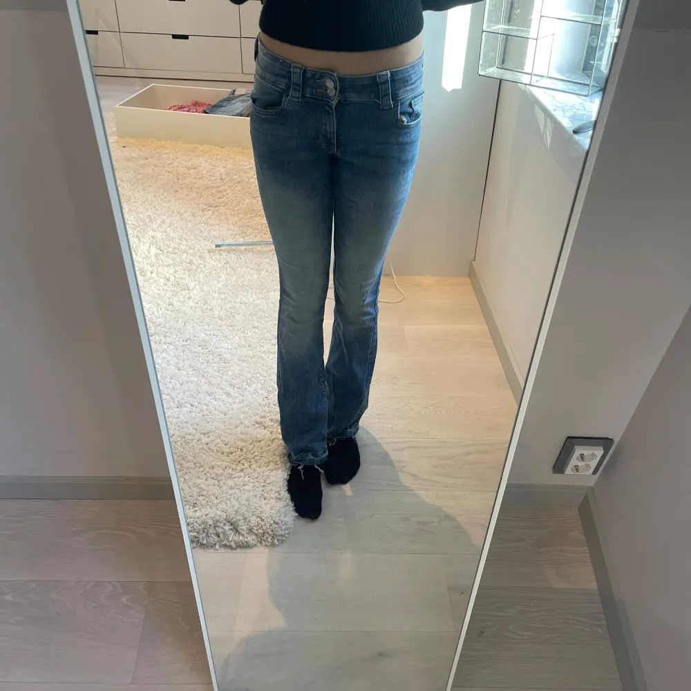 Säljer ett par snygga blå bootcut jeans från H&M. De har låg midja och justerbar midja för perfekt passform. Perfekta för en avslappnad stil.. Farkut & Housut.