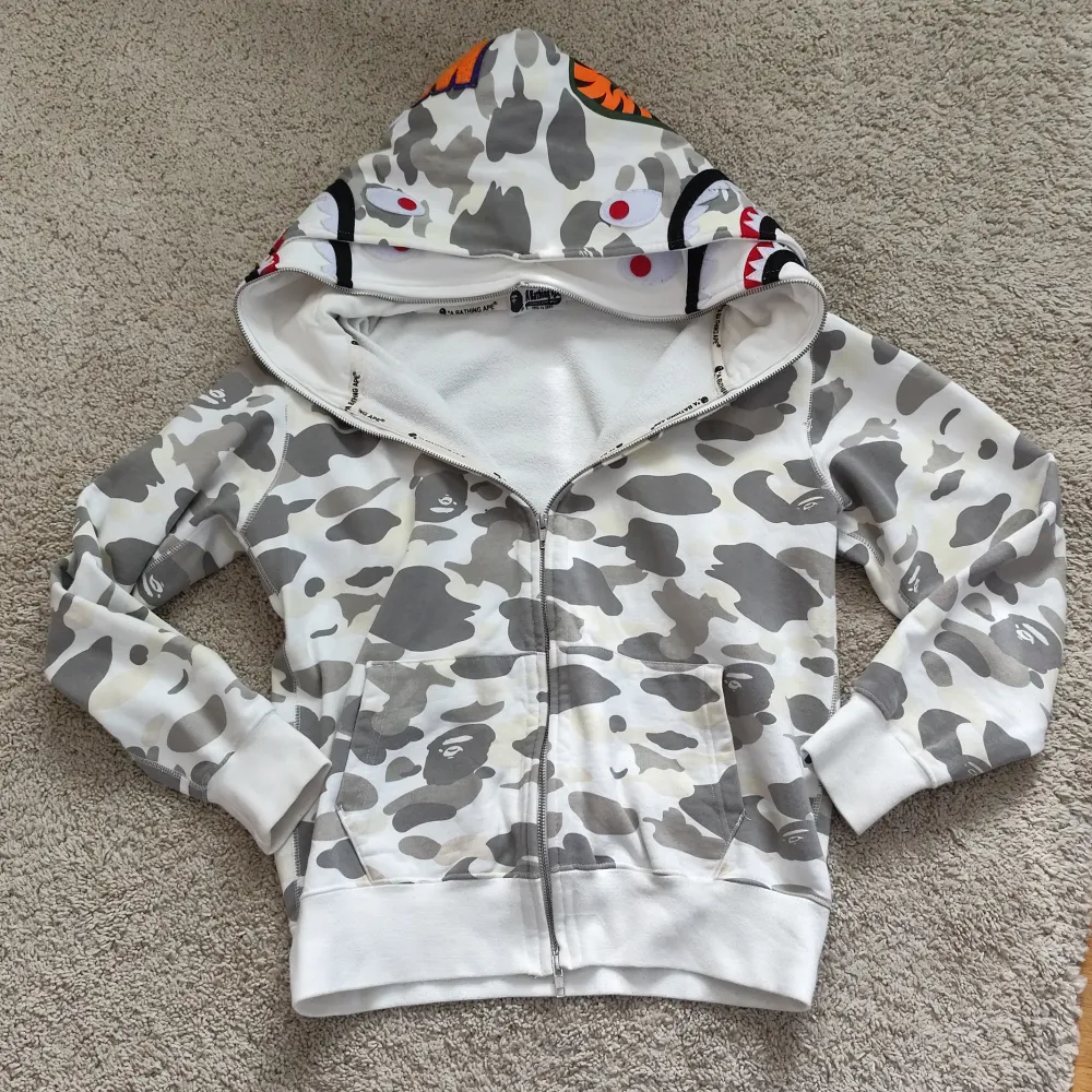 Äkta bape hoodie dubble hood limited edition. Den är äkta och går för 11 tusen nypris. Behövde byta ut kedjan men har kvar den orginala. Skriv pm för mer info och pris kan som alltid diskuteras!. Hoodies.