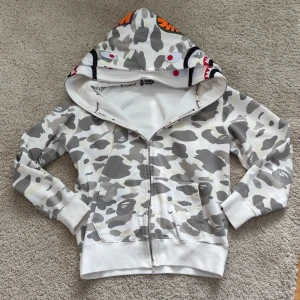 Äkta bape hoodie - Äkta bape hoodie dubble hood limited edition. Den är äkta och går för 11 tusen nypris. Behövde byta ut kedjan men har kvar den orginala. Skriv pm för mer info och pris kan som alltid diskuteras!