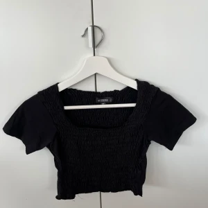 Svart kroppad t-shirt  - Jättefin kort topp med ribb liknande detaljer, fin kvadratisk urringning. Väldigt stretchig så kan även passa om man brukar ha större storlek🩷