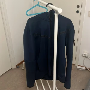 Mörkblå jacka från Nike - Säljer en mörkblå jacka från Nike. Den har en dragkedja framtill och är långärmad. Perfekt för höst och vår när det är lite kyligt ute. Jackan är i bra skick och redo för nya äventyr!