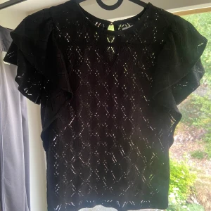 Svart topp med volangärmar - Säljer en snygg svart topp med volangärmar från Lindex i XS. Har bara använts en gång så den är som ny. 🩷🩷