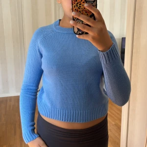 Blå stickad tröja från Calliope - Säljer en superfin blå stickad tröja från Calliope. Den är croppad och har en normal passform. Tröjan har långa ärmar och är perfekt för höst och vinter. Den är i nyskick och väldigt bekväm att ha på sig. 💙