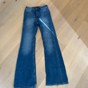 Blå bootcut jeans - Säljer ett par snygga blå hög midjade bootcut jeans. Dom är lite slitna längst ner på benen. 