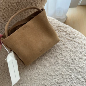 Arket Väska Mocka NY - Säljer denna. Liten väska i mocka från Arket. Nypris 1390. 