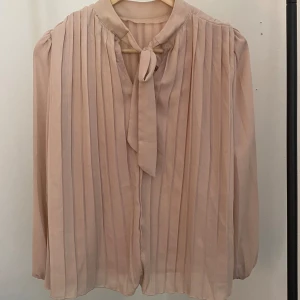 Rosa blus - Blindo storlek S, med innertyg (4de bilden) och därför inte genomskinlig. Söt rosett i nacken!  