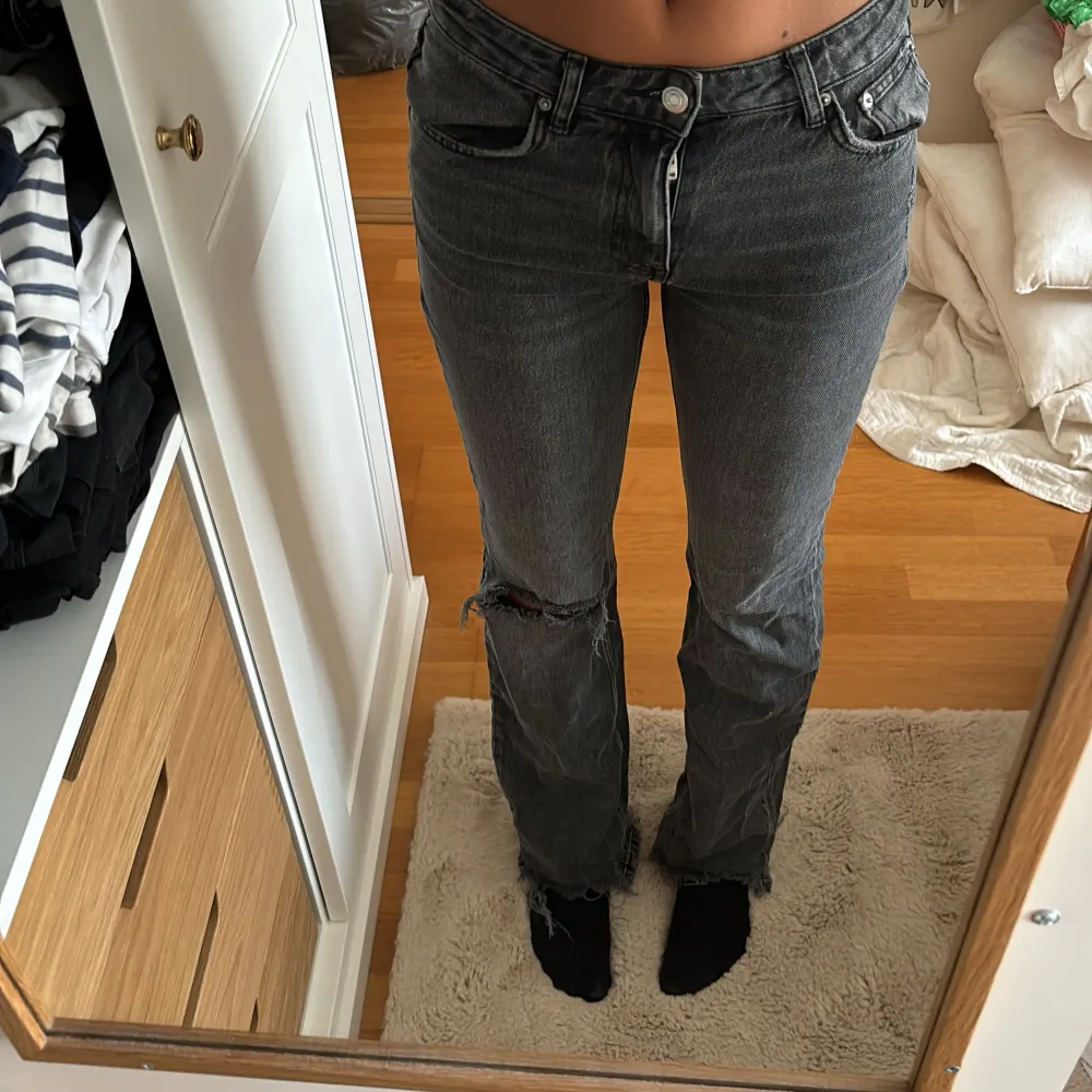 Säljer dessa super fina jeans från Gina Tricot i storlek 36. De är mörkgrå och bootcut med ett hål vid ena knät . Jeans & Byxor.