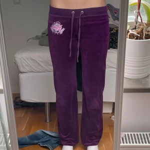Lila juicy couture byxor - Lågmidjade lila juicy byxor med gullig detalj på framsidan. Det står storlek M i byxorna men skulle säga att de passar mer som xs/s. Innerbenslängden är 75cm och midjemåttet 38cm. Skriv om du undrar något💗