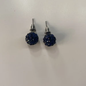Glittrande örhängen - Dessa par örhängen är i färgen marinblå och är glittriga. Som ni ser på 4 bilden har den ett litet märke tyvärr. Men syns nästan inte alls! Skriv till mig här på plick om ni är intresserade! 