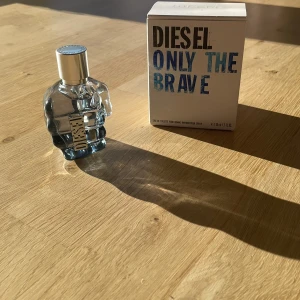 Diesel Only The Brave Parfym - Säljer en cool parfym från Diesel, Only The Brave. Flaskan är formad som en knytnäve i genomskinligt glas med en silverfärgad kork. Doften är maskulin och energisk, perfekt för den självsäkra personen. Kommer med originalförpackning.