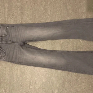 Grå jeansbyxor - Snygga grå jeansbyxor med en klassisk straight passform. De har en traditionell femficksdesign och är perfekta för en avslappnad stil. Byxorna har en diskret tvättning som ger dem en modern look.