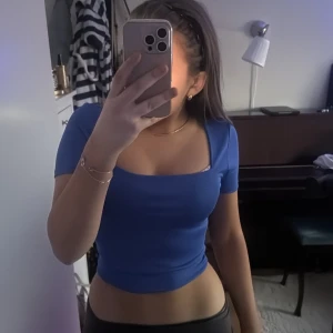 Blå croppad topp - Snygg blå croppad topp med korta ärmar och en tight passform. Perfekt för en trendig look. Det är storlek M men skulle säga att den mer passar som storlek S