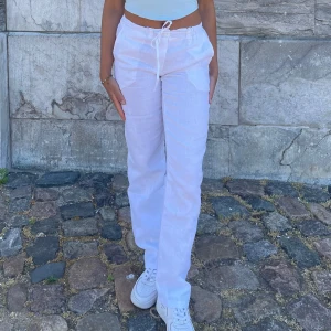 Lågmidjade linnebyxor - Snygga vita linnebyxor med avslappnad passform och snörning i midjan. Perfekta för varma sommardagar med sin lätta och luftiga känsla. Byxorna har en rak stil och sidfickor för extra bekvämlighet. Sprättat upp dom nertill så dom passar mig som är 167❣️