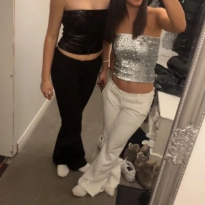 Glittrig tubtopp i silver - Snygg glittrig tubtopp i silver som endast ör använd en gång på nyår. Toppen är ärmlös och har en tight passform som framhäver figuren. Perfekt för att glittra på dansgolvet!