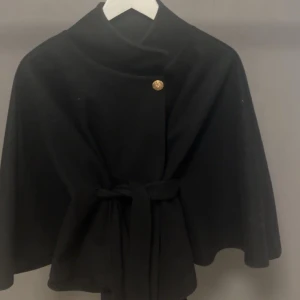Svart kappa från Missay - Svart kappa från Missay med en guldknapp upptill. Har använt den typ 2 gånger så är som ny!