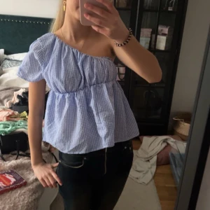 Rutig of shoulder topp - En blå vit rutig off shoulder/enärmad topp i superbra skick!! Storlek M men passar allt mellan XS och L då den är stretchig❣️