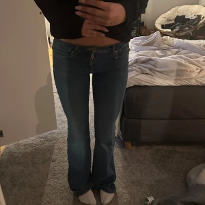 Blå bootcut jeans - Säljer ett par snygga blå bootcut jeans med låg midja. För långa på mig så lite lite slitningar längst ned, annars väldigt fina. 