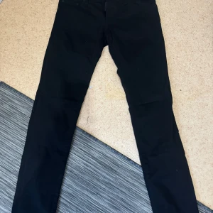 Svarta byxor från DSQUARED2 - Snygga svarta byxor från DSQUARED2 med en klassisk design. Byxorna har en rak passform och är tillverkade i ett slitstarkt material. Perfekta för en stilren look.