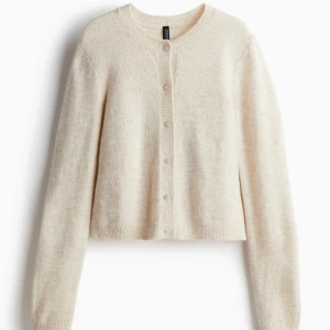 Beige kofta från H&M - Mysig beige kofta från H&M med knappar framtill. Den har en croppad passform och långa ärmar. Aldrig använd och lappen är kvar.🌟 Säljer då den var för liten. Köpt för 250kr