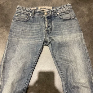 Blå jeans från Jacob Cohen - Snygga blå jeans från Jacob Cohen. Jeansen har en lätt tvättad look och är perfekta för en avslappnad stil. Märkeslappen syns tydligt på baksidan.