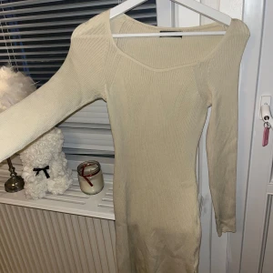 Beige ribbad klänning från Shein - Snygg beige ribbad klänning från Shein i en tight passform. Klänningen har långa ärmar och en stilren design som passar perfekt för olika tillfällen. Perfekt för dig som vill ha en enkel men elegant look.