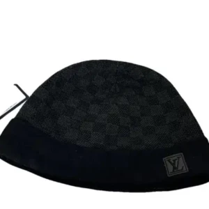 Svart rutig mössa från Louis Vuitton - Snygg svart mössa från Louis Vuitton med diskret rutigt mönster. Mössan har en elegant design med en liten logotyp framtill. Perfekt för att hålla stilen under kyligare dagar. Mössan är använd och lite mindre i storlek då den blivit tvättad men passar om du inte har för stort huvud.