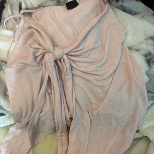 Ljusrosa topp från Gina Tricot - Säljer en söt ljusrosa topp från Gina Tricot med knytning framtill. Toppen har smala axelband och en mjuk, flödande design som ger en romantisk känsla. Perfekt för varma dagar eller speciella tillfällen. 💖