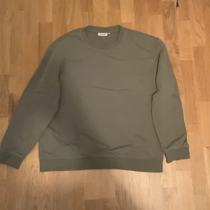 Olivgrön tröja från Dobber  - Säljer en stilren olivgrön tröja från Dobber. Tröjan är i strl L men passar M/L. Den är i fint skick då den inte använts så många gånger