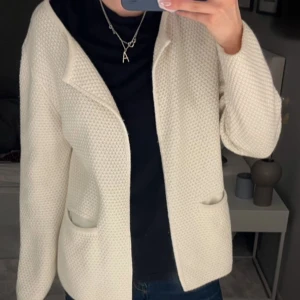 Beige stickad kofta från Sibin Linnebjerg - Säljer en superfin beige stickad kofta från Sibin Linnebjerg. Den har en öppen design med långa ärmar och två praktiska fickor framtill. Perfekt för både höst och vår när du vill ha något mysigt och stilrent. Passar till alla tillfällen!