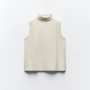 Beige ärmlös polotröja - Snygg beige ärmlös polotröja med ribbad krage. Perfekt för lager-på-lager-stil eller som ett stilrent plagg i sig. Enkel och elegant design som passar till många olika outfits.