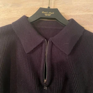 Svart stickad tröja med dragkedja - Helt ny och helt oanvänd i storlek M/S. Säljer en stilren svart stickad tröja. Tröjan har en dragkedja framtill och en klassisk krage. 