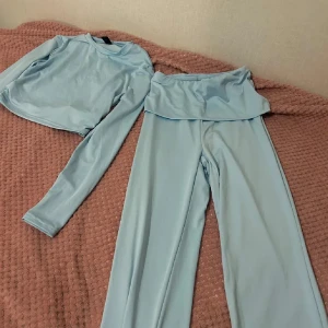 Ljusblå croppad set - Snyggt ljusblått set med croppad topp och matchande byxor. 