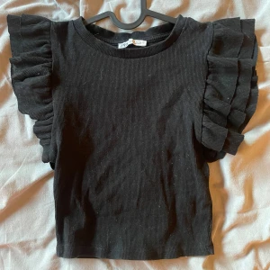 Zara volangtopp  - Supersöt svart ribbad topp med volangärmar från Zara! Använd någon gång men väldigt bra skick, passar perfekt nu när våren är påväg🥰