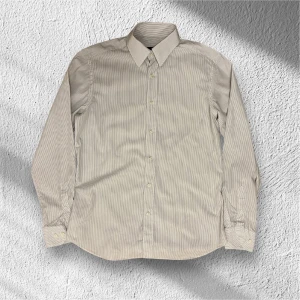 Randig skjorta från Massimo Dutti - Snygg och stilren randig skjorta från Massimo Dutti i slim fit. Skjortan har långa ärmar och knappar framtill. Perfekt för en elegant look. Skjortan är i väldigt fint skick. Mitt pris är 199kr men om man är eller blir en följare får man den för endast 179kr. Ställ gärna frågor!