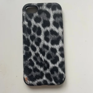 Leopardmönstrat mobilskal - Snyggt mobilskal med leopardmönster i svart och grått. Skalet har en texturerad yta som ger ett bra grepp och skyddar din mobil. Perfekt för att ge din telefon en trendig look.
