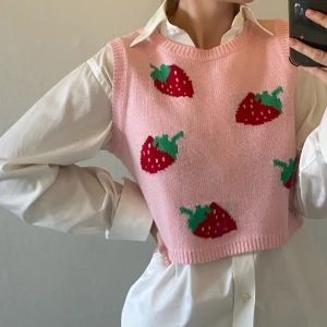 Rosa stickad väst med jordgubbsmönster - Söt rosa stickad väst med jordgubbsmönster💕🍓 står ingen storlek men passar XS-M beroende på vilken passform man vill ha 