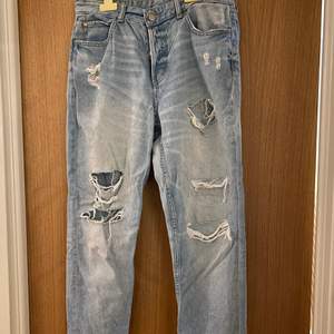 Slitna jeans, (skulle inte säga att dom är low waist, mer mid waist) Knappar inte gylf. Bra passform.
