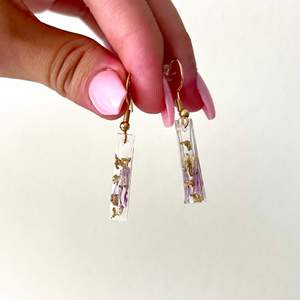 Handgjorda örhängen i resin med rosa/lila klöverblommor och gulddetaljer! ☘️✨ Själva örhänget är i guldfärgspläterat kirurgiskt stål och är allergivänligt 🌞
