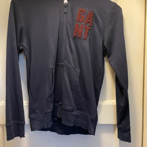 Hoodie Gant Stl 158/164 - Skön favorit som tyvärr blivit urvuxen. Mörkblå med röd text. Ärmen lite sliten. 