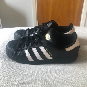 Adidas superstar - Svarta adidas superstar skor.. Är i bra skick utan några ytliga defekter. De är lite slitna på innersidan av hälen på ena skon och loggan på innersulan har också börjat försvinna lite, men inger överdrivet. Är i storlek 40. Hör av er vid frågor!