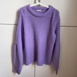 Lila stickad tröja - Helt ny stickad tröja i fin lila färg. Storlek L men sitter snyggt oversized om man har mindre storlek! Lite ljusare färg i verkligheten Frakt tillkommer