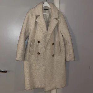 Lång kappa - En vit lång kappa från Gina.